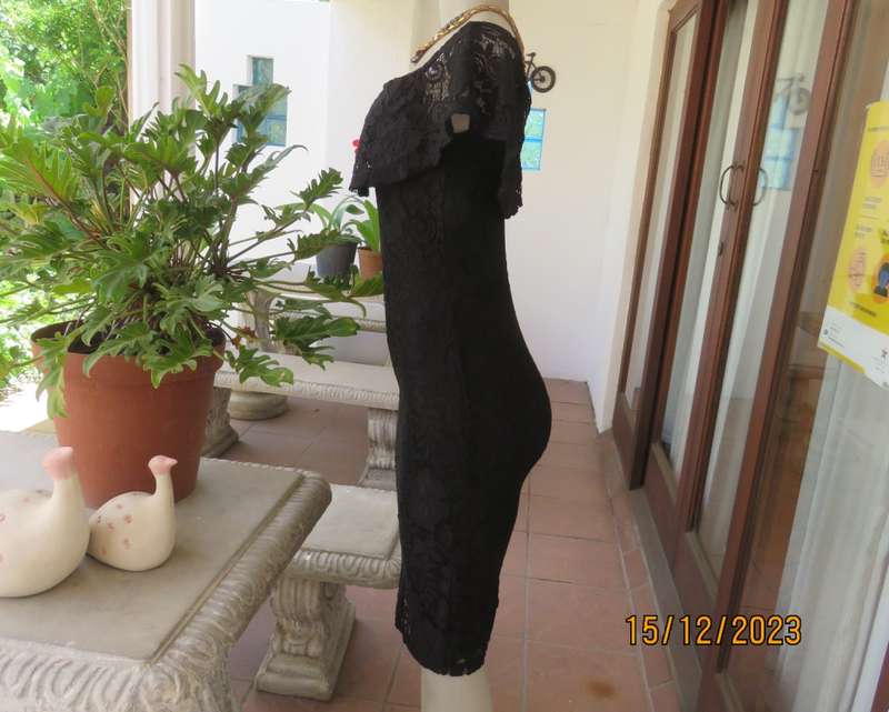 The little black poly/nylon lace dress. Lining stretch poly. Off shoulder/frilled neckline.Size 32