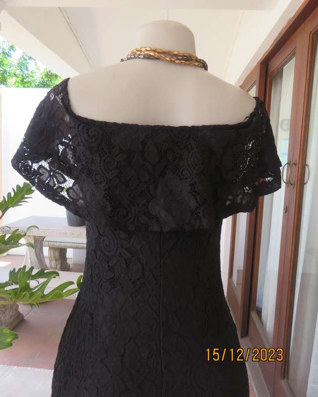 The little black poly/nylon lace dress. Lining stretch poly. Off shoulder/frilled neckline.Size 32