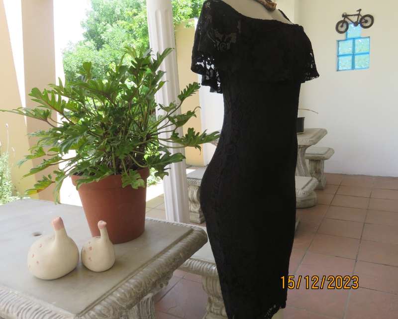The little black poly/nylon lace dress. Lining stretch poly. Off shoulder/frilled neckline.Size 32