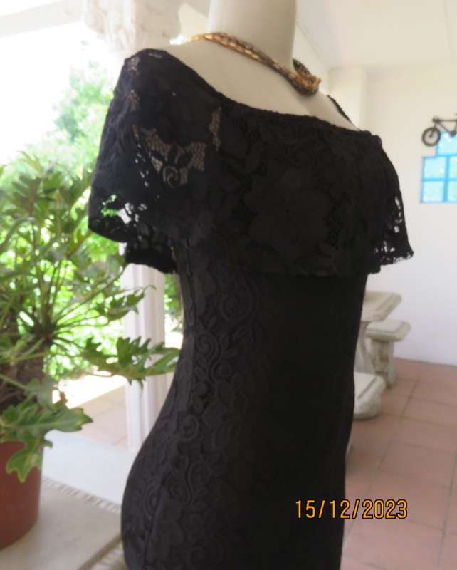 The little black poly/nylon lace dress. Lining stretch poly. Off shoulder/frilled neckline.Size 32