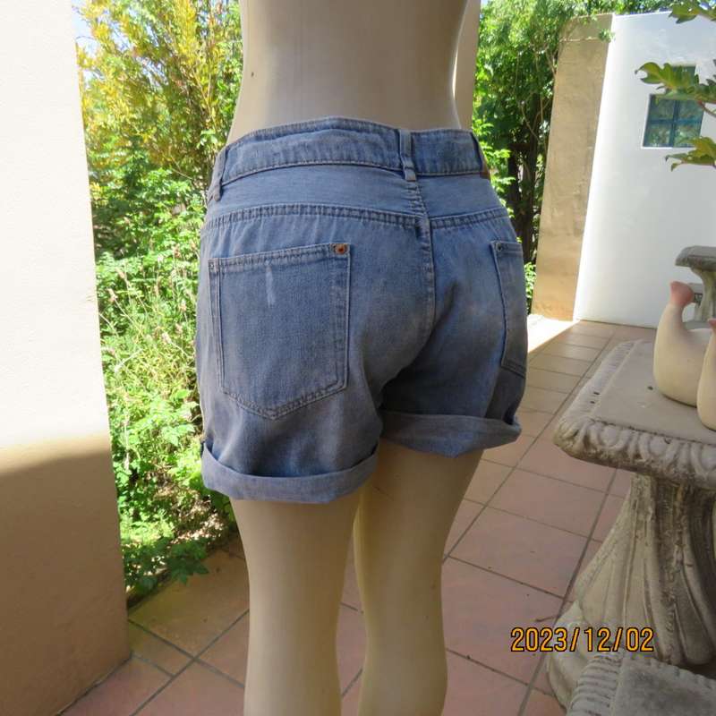 Distressed look denim shorts size 38/14 with turnover legs. Buttoned fly. Pockets back/front.