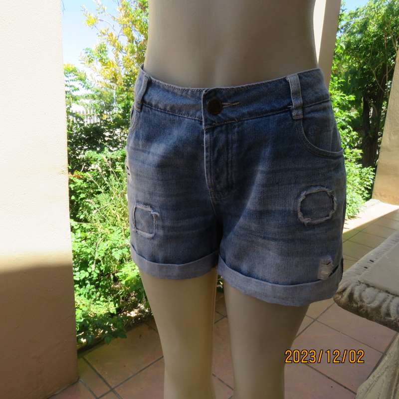 Distressed look denim shorts size 38/14 with turnover legs. Buttoned fly. Pockets back/front.