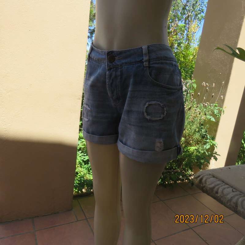 Distressed look denim shorts size 38/14 with turnover legs. Buttoned fly. Pockets back/front.