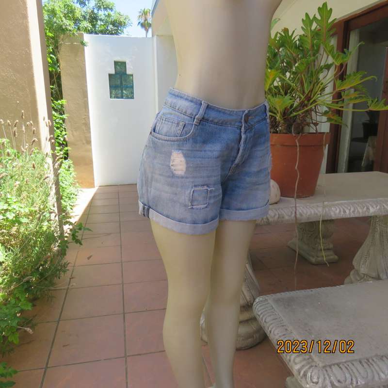 Distressed look denim shorts size 38/14 with turnover legs. Buttoned fly. Pockets back/front.