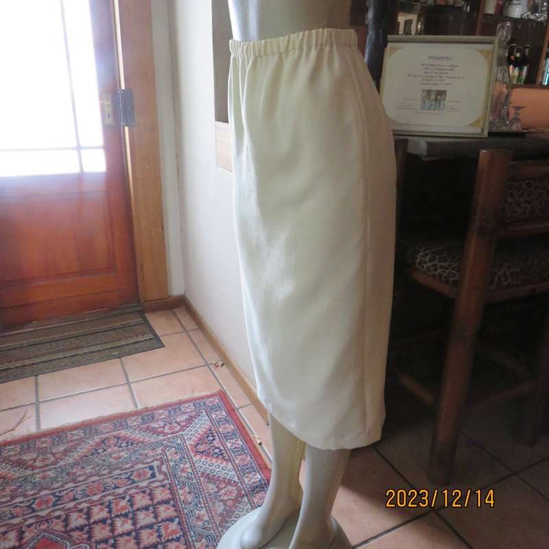 Easy to wear cream fully lined pencil skirt in textured polyester. Boutique made size 40. New cond.