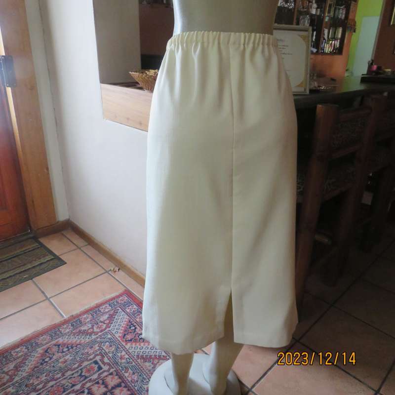 Easy to wear cream fully lined pencil skirt in textured polyester. Boutique made size 40. New cond.