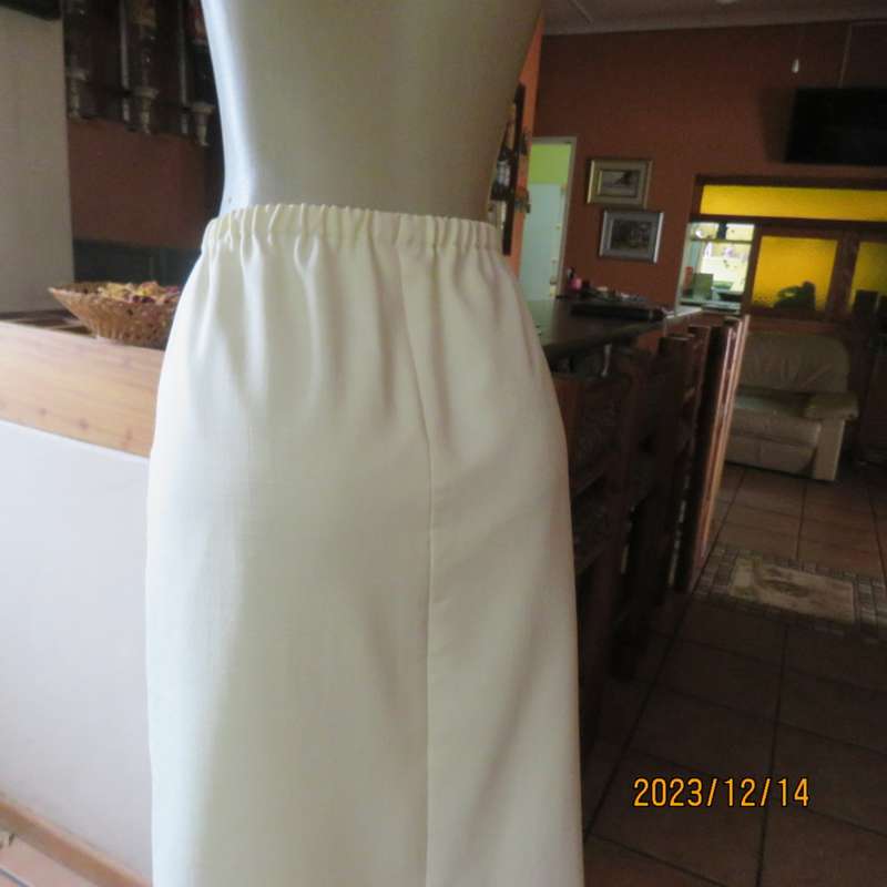 Easy to wear cream fully lined pencil skirt in textured polyester. Boutique made size 40. New cond.