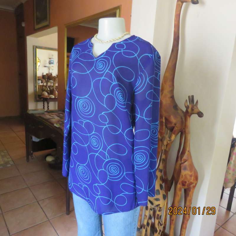 Make a statement in this indigo blue long sleeve top with turquoise twirls.Size 36.By FOSHINI.As new