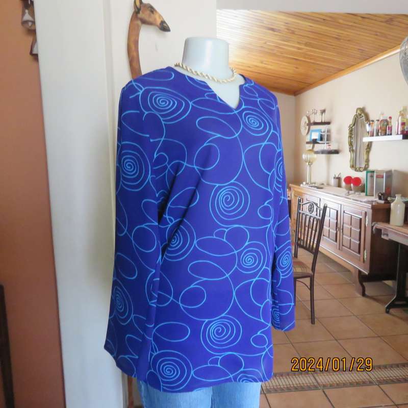 Make a statement in this indigo blue long sleeve top with turquoise twirls.Size 36.By FOSHINI.As new