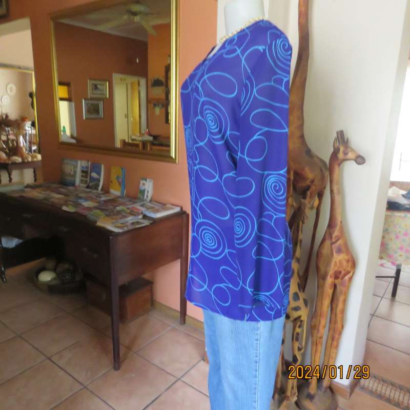 Make a statement in this indigo blue long sleeve top with turquoise twirls.Size 36.By FOSHINI.As new