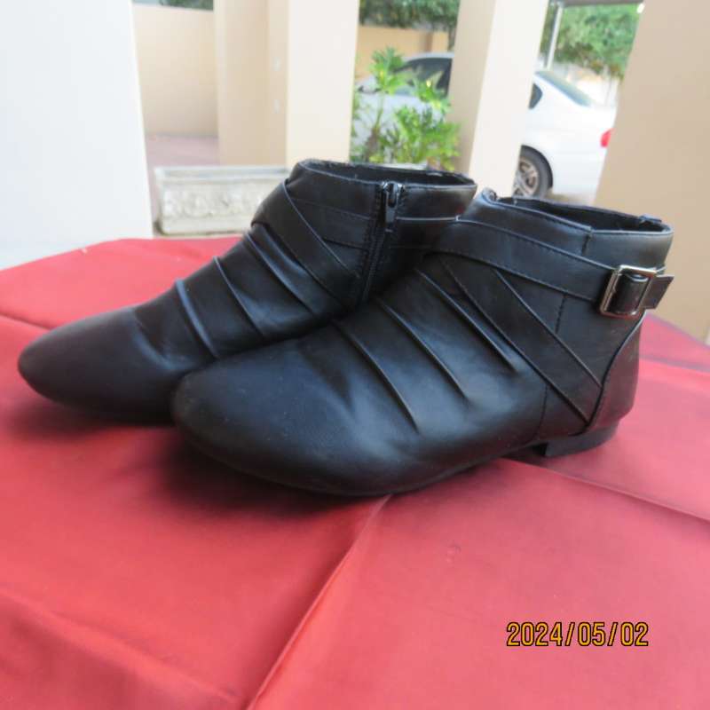 Pair of black faux leather booties in size 9 with side zips. Also an adjustable strap. Very good con