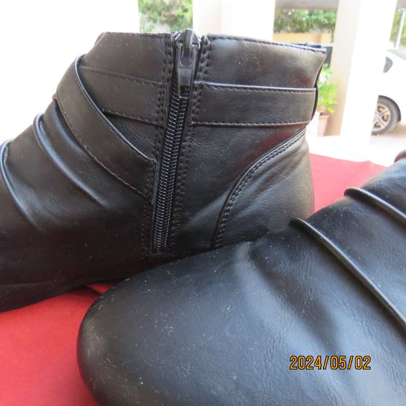 Pair of black faux leather booties in size 9 with side zips. Also an adjustable strap. Very good con