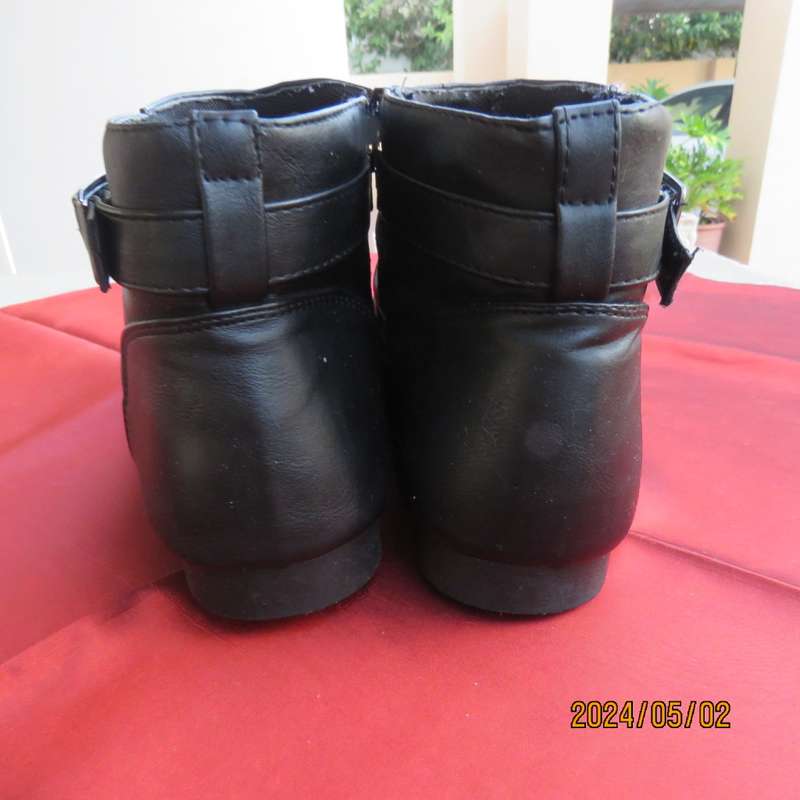 Pair of black faux leather booties in size 9 with side zips. Also an adjustable strap. Very good con