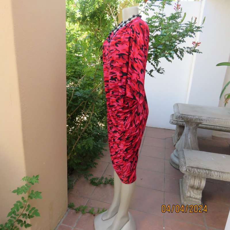 Go for effortless style in this slip over dress in medley of patterns in reds/black.Size 36/38.