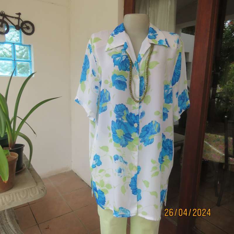 Get noticed in this white short sleeve top with bold blue/green flowers.Size 42. New cond.