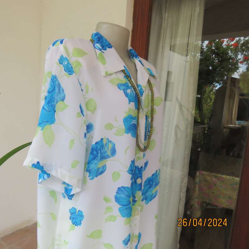 Get noticed in this white short sleeve top with bold blue/green flowers.Size 42. New cond.
