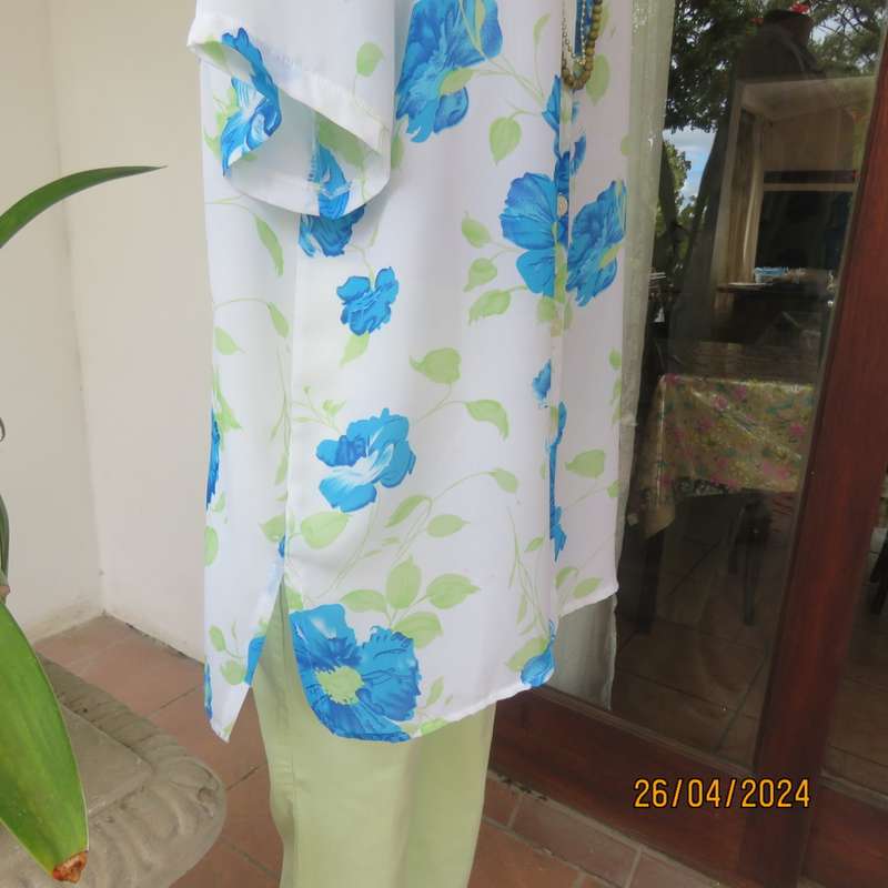 Get noticed in this white short sleeve top with bold blue/green flowers.Size 42. New cond.
