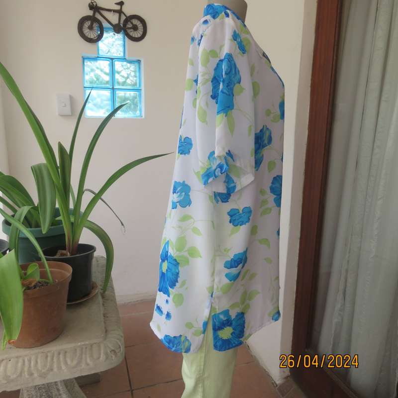 Get noticed in this white short sleeve top with bold blue/green flowers.Size 42. New cond.