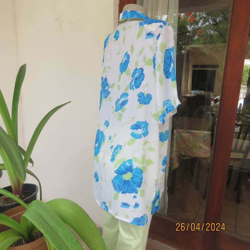 Get noticed in this white short sleeve top with bold blue/green flowers.Size 42. New cond.