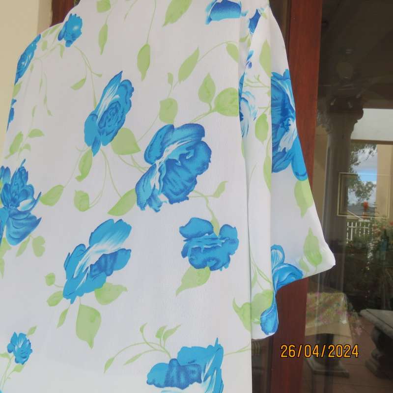 Get noticed in this white short sleeve top with bold blue/green flowers.Size 42. New cond.