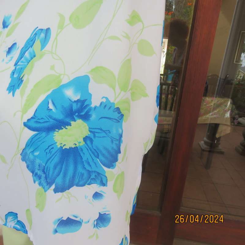 Get noticed in this white short sleeve top with bold blue/green flowers.Size 42. New cond.