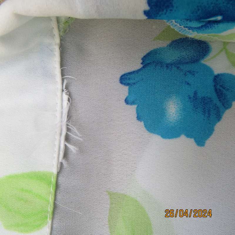 Get noticed in this white short sleeve top with bold blue/green flowers.Size 42. New cond.