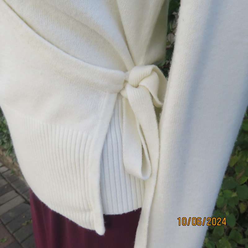 Soft cream foldover acrylic knit top with long sleeves. Straps at side to tie. Decoration left. 34.