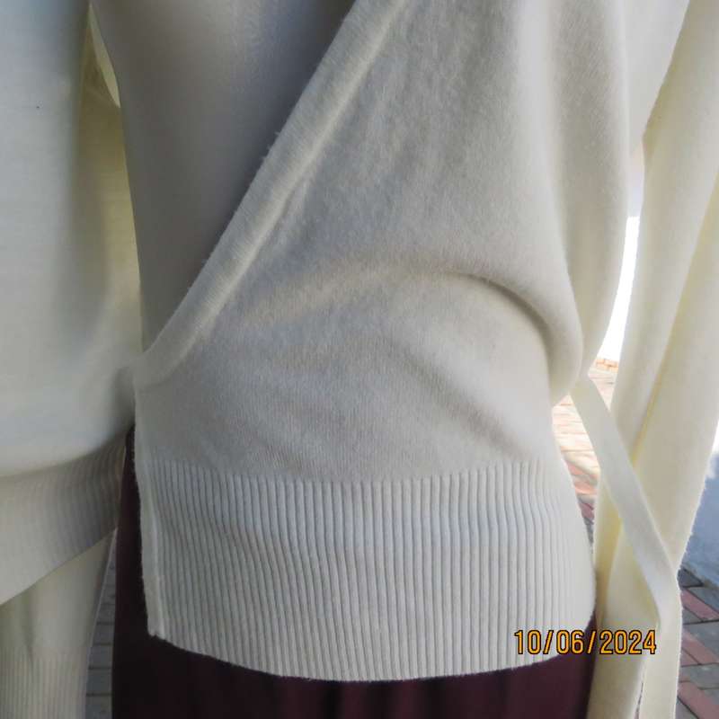 Soft cream foldover acrylic knit top with long sleeves. Straps at side to tie. Decoration left. 34.