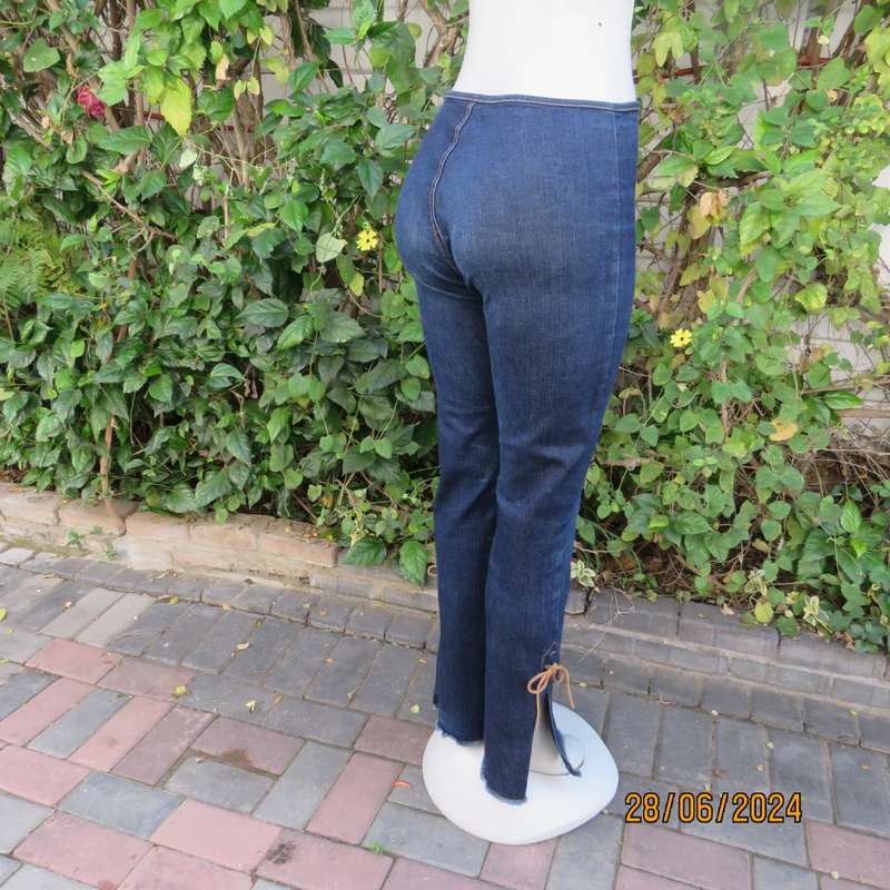 Bandless blue denim skinny jeans. Stretch polyester. High leg side slits.Leather tiestrings. Size 32