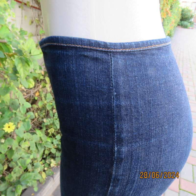 Bandless blue denim skinny jeans. Stretch polyester. High leg side slits.Leather tiestrings. Size 32