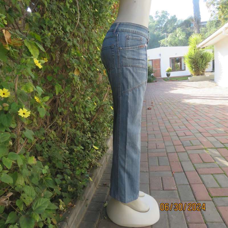 Bootcut blue denim size 32 jeans with distressed look. Pockets. Front seams. Polycotton stretch.