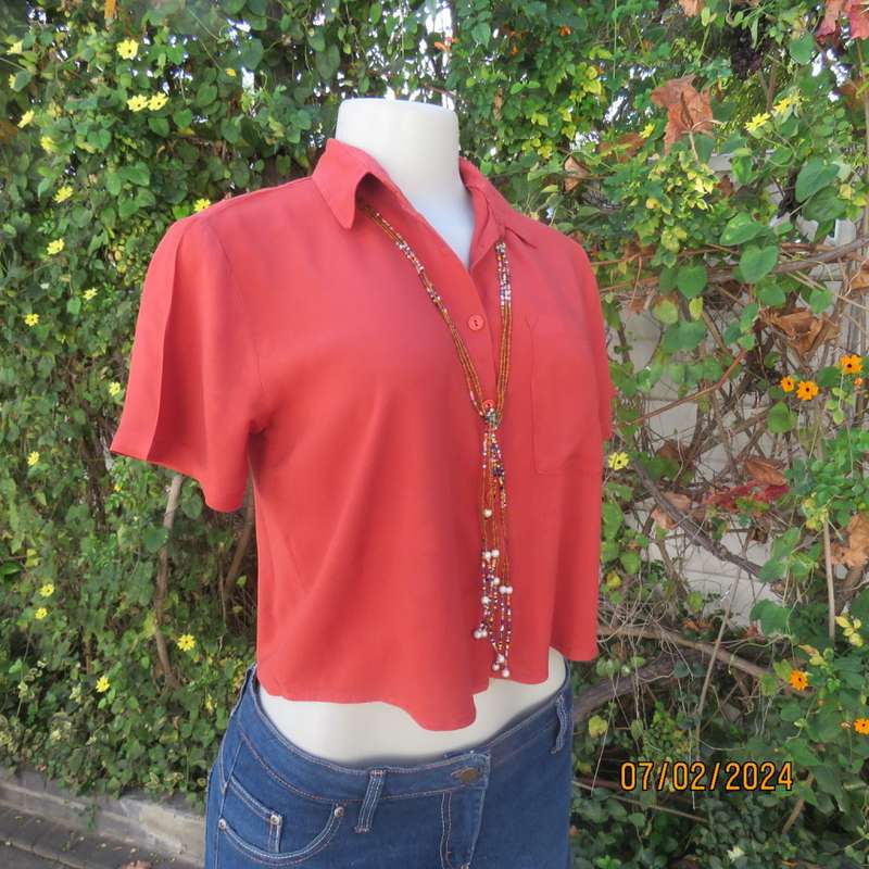 Cute burnt orange colour button down/shirt collar cropped top.One pocket. Size 34. As new.
