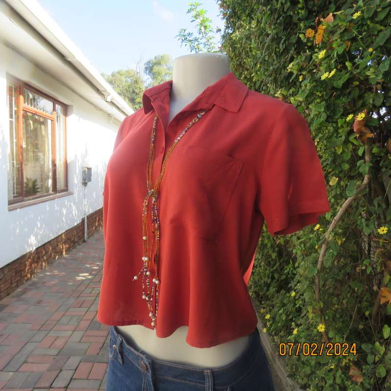 Cute burnt orange colour button down/shirt collar cropped top.One pocket. Size 34. As new.