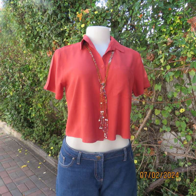 Cute burnt orange colour button down/shirt collar cropped top.One pocket. Size 34. As new.