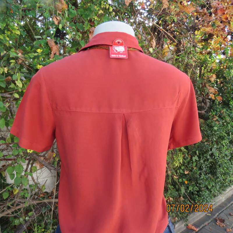 Cute burnt orange colour button down/shirt collar cropped top.One pocket. Size 34. As new.