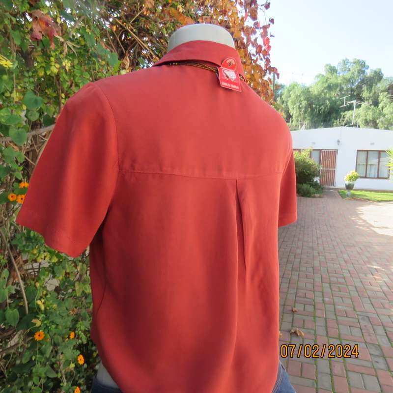 Cute burnt orange colour button down/shirt collar cropped top.One pocket. Size 34. As new.