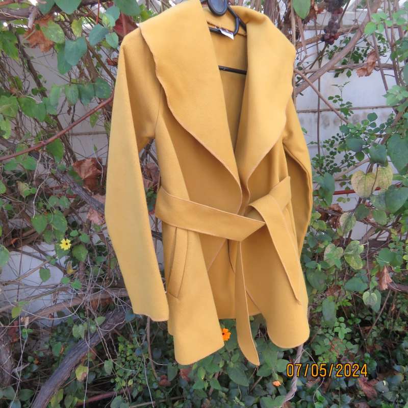 Mustard colour fold over warm jacket for 9 to 10 yr old girl. By IQ. Two pockets. Band around waist.