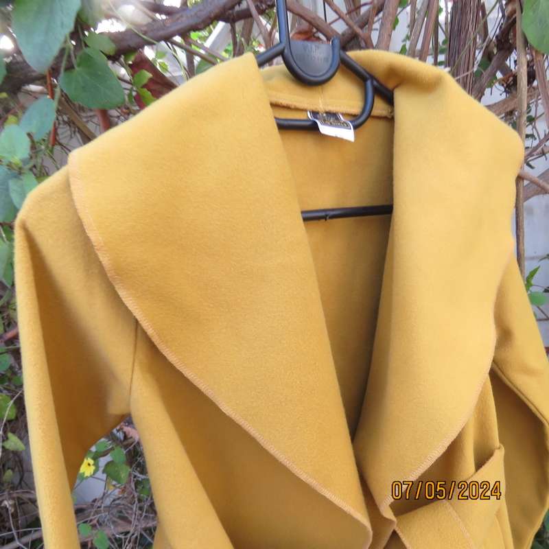 Mustard colour fold over warm jacket for 9 to 10 yr old girl. By IQ. Two pockets. Band around waist.