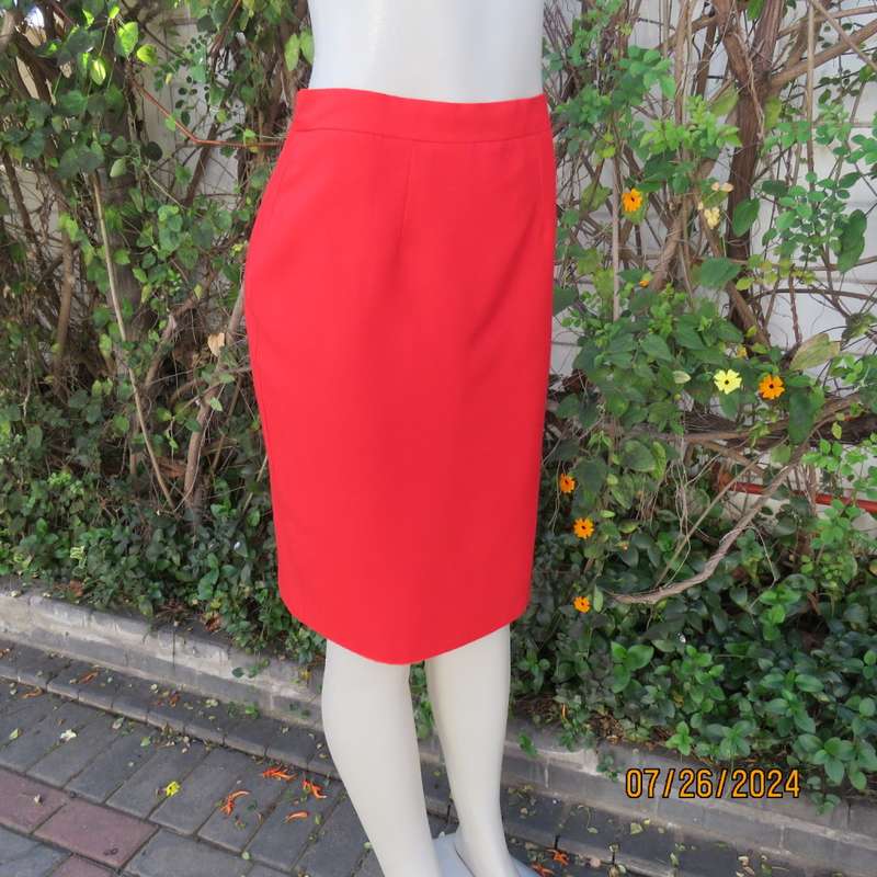 Bright red knee length lined pencil skirt in poly/viscose. By KELSO Petite size 35.Back zip/pleat.