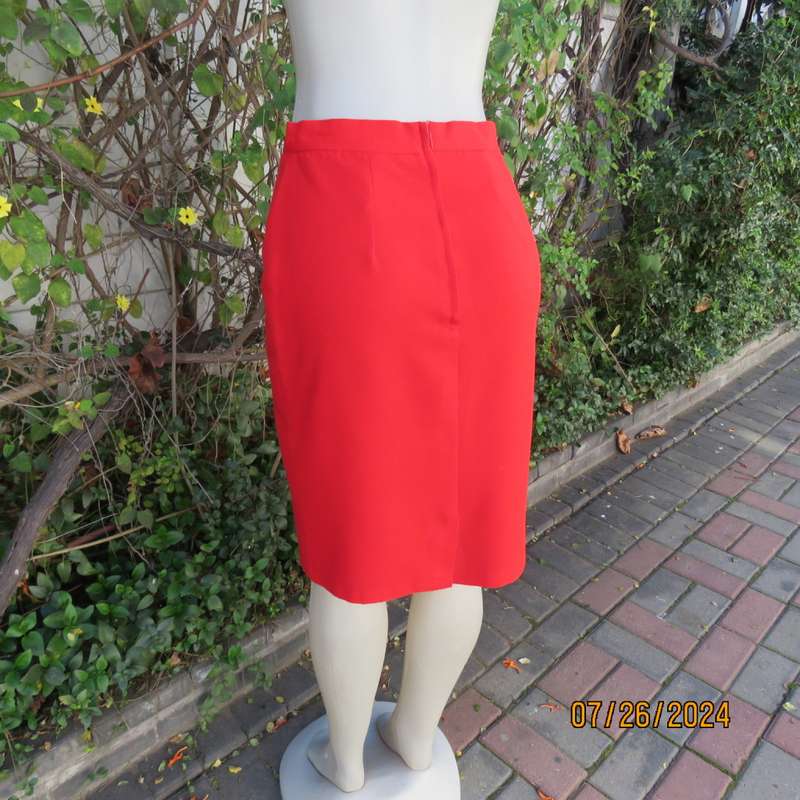 Bright red knee length lined pencil skirt in poly/viscose. By KELSO Petite size 35.Back zip/pleat.