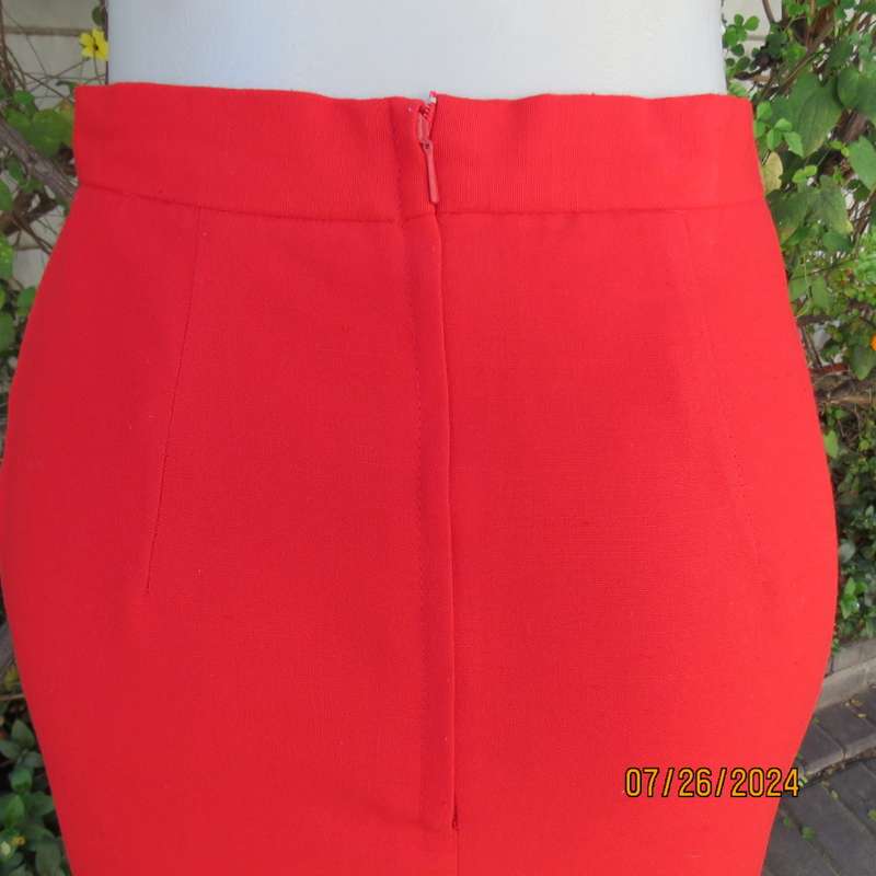 Bright red knee length lined pencil skirt in poly/viscose. By KELSO Petite size 35.Back zip/pleat.
