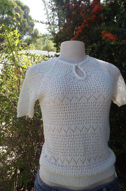 Beautiful knitted acrylic top in beige with lace pattern.Will fit 32/8. New condition