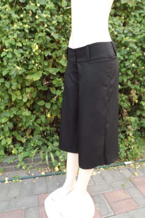 Black culotte knee length pants by Classic Fashion.Size 32/8.In shiny wash&wear polyester fabric.