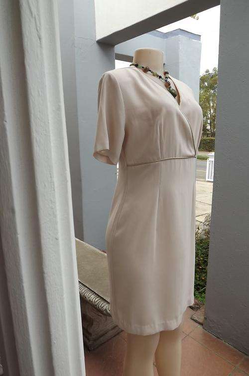 Crepe polyester elegant dress in Beige.Size 34/10 by Foshini.Cross over bodice and paneled bottom.