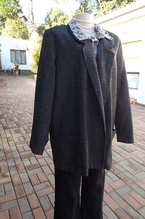 Tweed unlined Boutique made jacket in size 48/24.Loose hanging with 2 front pockets.Close with 2 but