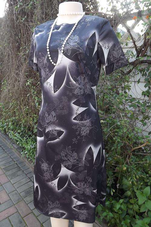 Elegant plain short sleeve black sheath dress in size 34/10.Silver grey leaf design.New condition