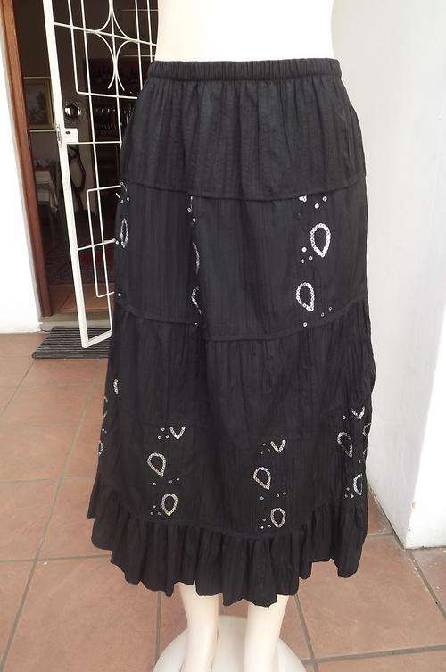Black creased polyester tiered skirt with short lining.Size 34/10.Decorated with sequined patterns.