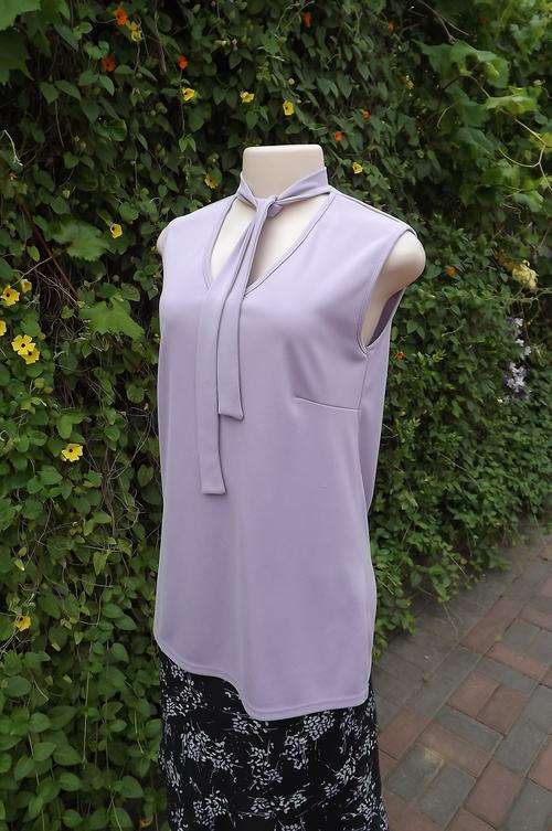 Pretty lavendar stretch polyester sleeveless top size 36/12 with V neckline.Banded collar tie.