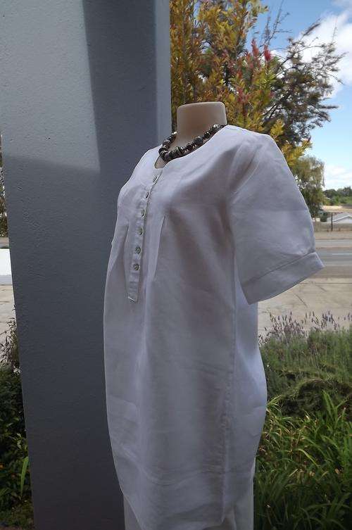 White 100% linen top with short sleeves and long length.Size 36/92.Four stitched pleats on front.