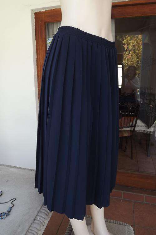Navy permanent pleated skirt with knife pleats.Elasticated middle.Size 36/12 by Varity.Length 75cm.